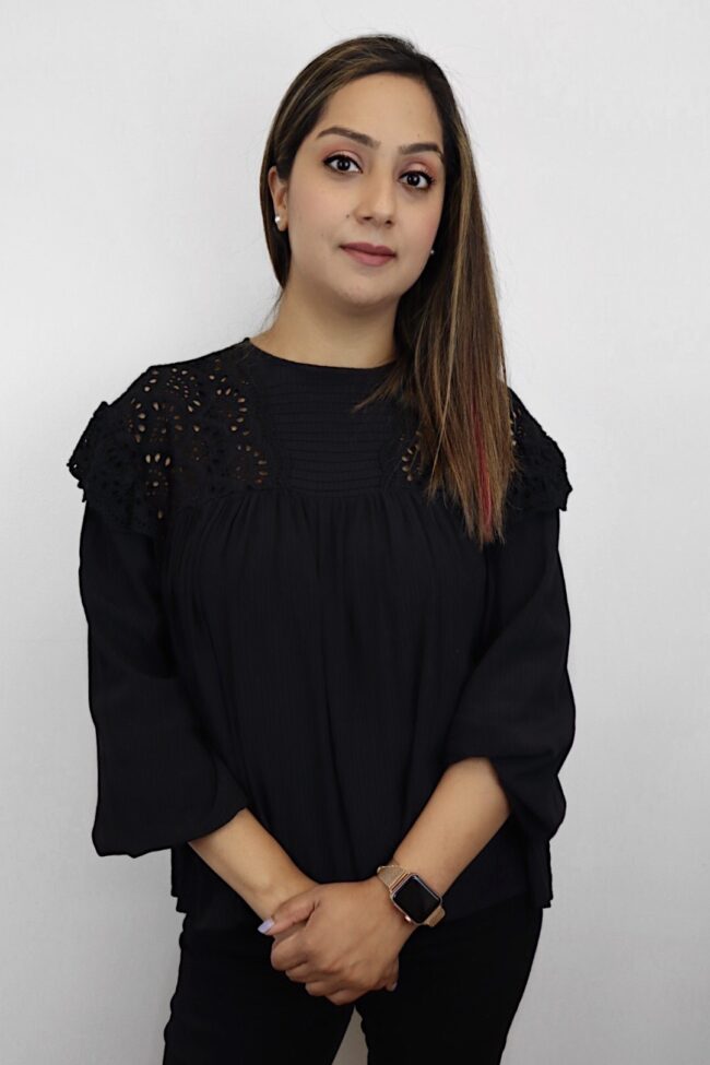 Woman in black eyelet blouse and watch.