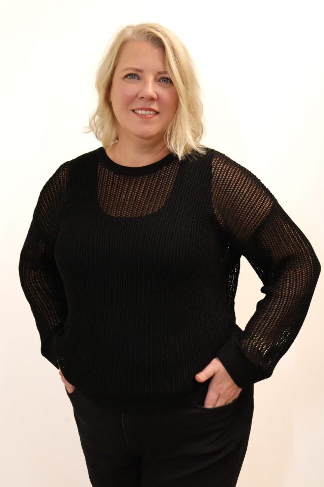 Woman in black knit sweater.
