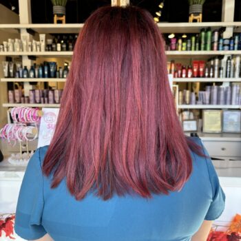 Woman's back, long burgundy hair.